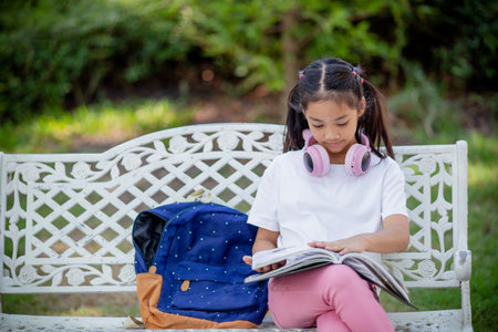 Back to school. Asian girl reading a book. Primary school students after classes learning homework.の写真素材