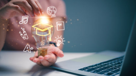 Women holding lightbulb and graduation hat, Internet education course degree, study knowledge to creative thinking idea and problem solving solution. E-learning graduate certificate program concept.の写真素材