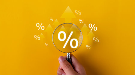 Interest rate and dividend concept. magnifying glasses and percentage symbols and an up arrow, interest rates continue to increase, and return on stocks and mutual funds. on yellow backgroundの写真素材
