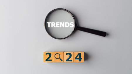 2024 trends concept. Magnifying glass and wooden cubes with the word Trends. Banner of business...