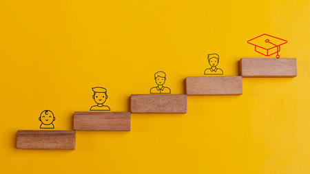 Wooden cubes with the evolution of a person from birth to graduation. Graduation from university, education, and educational development of a person.の写真素材