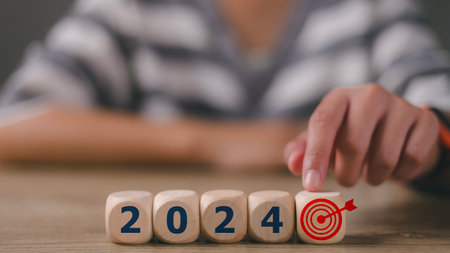Businesswoman touching target icon wooden block cube from  2024 setup objective target business cost...