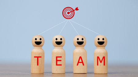 Wooden figures smile faces with team wording on the body and target icons. Teamwork and Ideas for business corporation concept. Business target and team concept.の写真素材