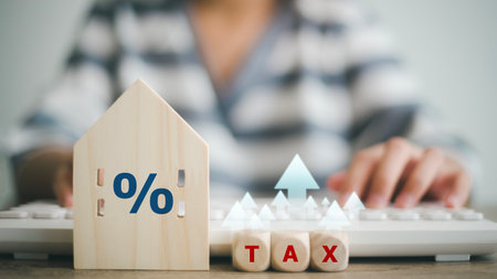 The concept of paying state property tax. A businesswoman with a wooden house with a percent sign and arrow up house stands.の写真素材