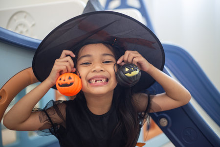 Happy Asian child girl in a witch costume to Halloween. trick or treat. Kids trick or treating.の写真素材