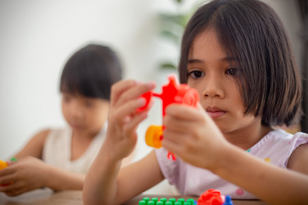Adorable little girl playing toy blocks in a bright roomの写真素材