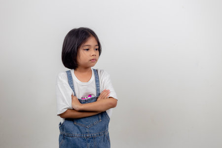 Angry little girl over white background, sign and gesture conceptの写真素材