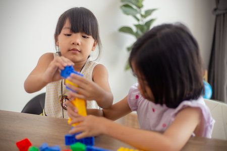 Adorable little girl playing toy blocks in a bright room