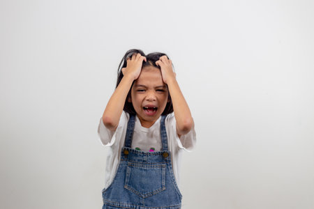 Angry little girl over white background, sign and gesture conceptの写真素材