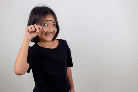 little girl looking through a magnifying glassの写真素材