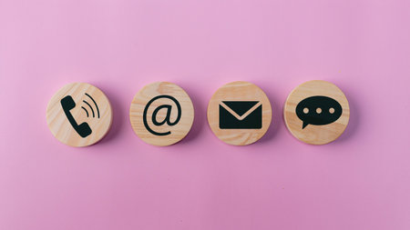 Contact icons include message address e-mail and telephone on wooden block cube and blue background...