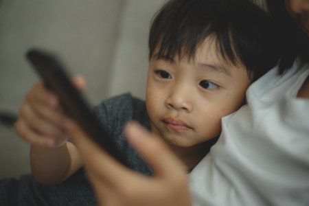 Child-addicted phone concepts. Asian boy playing smartphone, kid use telephone, watching smartphone.の写真素材