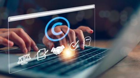 Copyright or patent concept, Person's hand using a laptop computer on a futuristic virtual interface screen. copyright icon background, Creation ownership against piracy crimeの写真素材