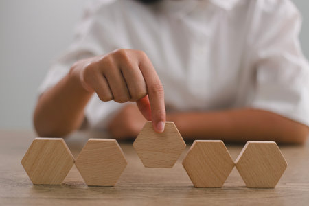 Businesswomen stack blank wooden cubes on the table with copy space, empty wooden cubes for input wording, and an infographic iconの写真素材