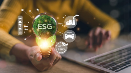 Businesswoman hand holding light bulb with esg icon on virtual screen, ESG Environmental, social and corporate governance conceptの写真素材