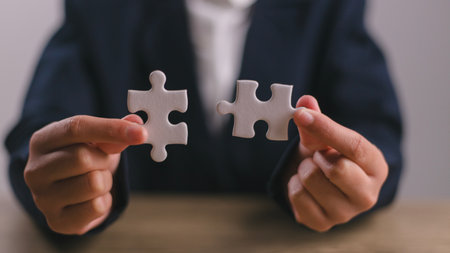 Business solutions, success, and strategy concept. Businessman hand connecting jigsaw puzzle.