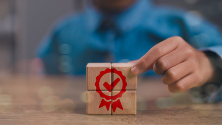 Quality warranty concept. Man hand puts the wooden cubes with quality warranty icon on wooden cubes....