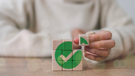 Wooden cube with a green checkmark icon. Corporate regulatory and compliance. Goals achievement and business success. Task completion. Ethical corporate. Do the right thing. Quality and ISO symbol.の写真素材