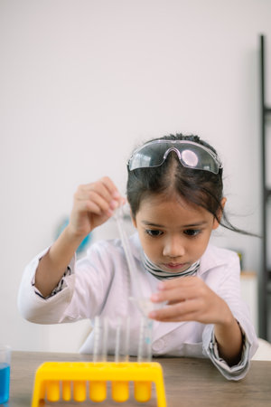Asian child girl learning science chemistry with test tube making experiment at school laboratory. education, science, chemistry, and children's concepts. Early development of children.の写真素材
