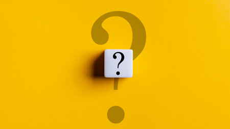 A white cube with a black question mark on it is on a yellow background. The cube is placed in the...