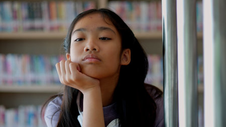 An Asian woman sits, her face full of stress, boredom, and disappointment.の写真素材