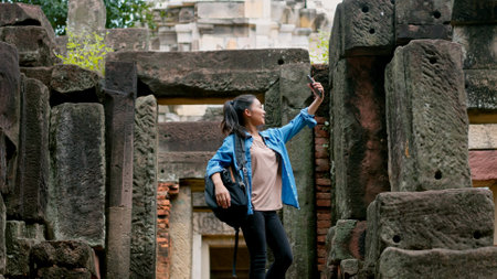 An Asian woman explores the Phanom Wan Stone Castle and takes photos of the impressive sight.の写真素材