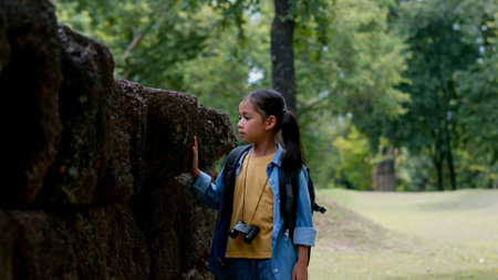 An Asian woman explores a stone castle using binoculars to admire its stunning architecture.の写真素材