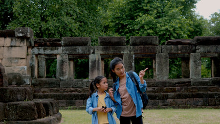 Two Asian siblings explore the Phnom Wan Stone Castle, admire the ancient architecture and take photos to record their memories.の写真素材
