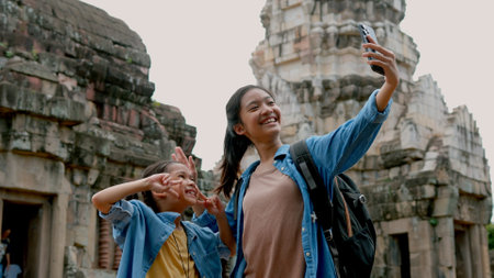 Two Asian siblings explore the Phnom Wan Stone Castle, admire the ancient architecture and take photos to record their memories.の写真素材