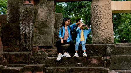 Two Asian siblings explore the Phnom Wan Stone Castle, admire the ancient architecture and take photos to record their memories.の写真素材
