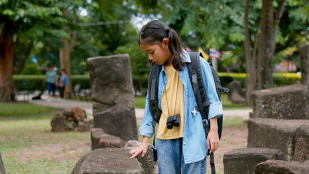 An Asian woman explores a stone temple using binoculars to admire its stunning architecture.の写真素材