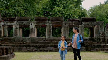 Two Asian siblings explore the Phnom Wan Stone Castle, admire the ancient architecture and take photos to record their memories.の写真素材
