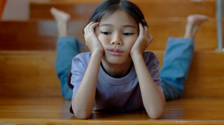 An Asian girl is lying on the stairs with a bored expression and looking around.の写真素材