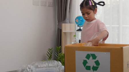 Asian little Girls dump plastic bottles in recycling boxes to reduce trash, reuse, and recycle. Recyclability and sustainability concept.の写真素材