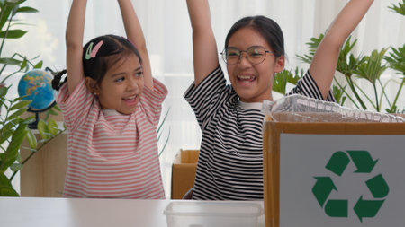 Asian siblings recycle household waste, Protect nature, and save the environment. children learn to sort garbage by putting plastic bottles in the recycleの写真素材