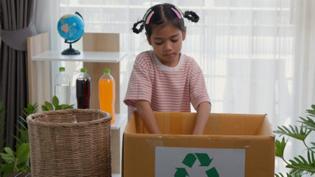 Asian little Girls dump plastic bottles in recycling boxes to reduce trash, reuse, and recycle. Recyclability and sustainability concept.の写真素材