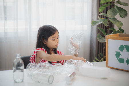 Asian little Girls dump plastic bottles in recycling boxes to reduce trash, reuse, and recycle....