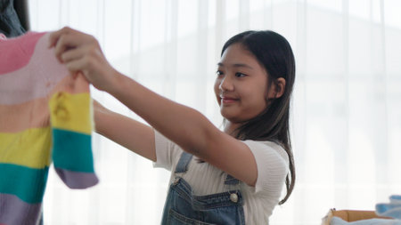 Recycling, Donation for poor, Asian girls packing objects at home, putting on stuff into donate box with second hand clothes, charity helping and needy people. Reuse recycle, moving.の写真素材