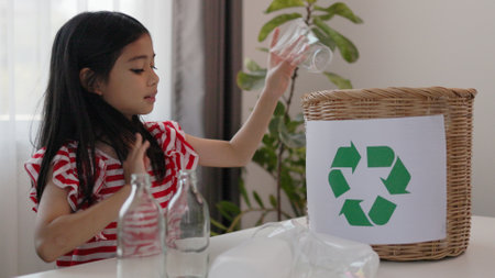Asian little Girls dump plastic bottles in recycling boxes to reduce trash, reuse, and recycle. Recyclability and sustainability concept.の写真素材