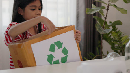 Asian little Girls dump plastic bottles in recycling boxes to reduce trash, reuse, and recycle. Recyclability and sustainability concept.の写真素材