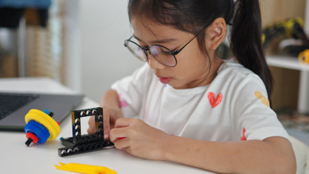 STEM education concept. Asian home school girls self-study online lessons and are excited to make STEM toys. mathematics engineering science technology computer code in robotics for kids' concepts.の写真素材