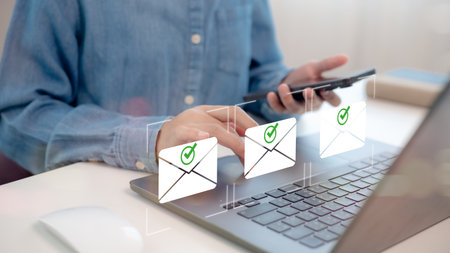 Businessmen use a laptop to send emails to customers. Business contact and communication, mail icons, email marketing concept. Send e-mail or newsletter, online internet promotion to increase sales.の写真素材
