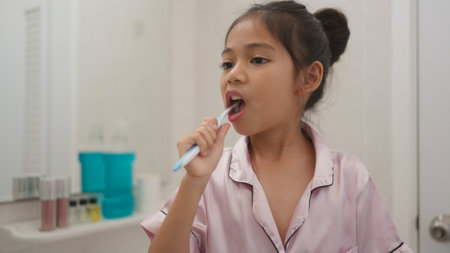 Morning routine, smiling happy Asian girls brushing teeth with a toothbrush. Dental hygiene of little girls, medical care.の写真素材