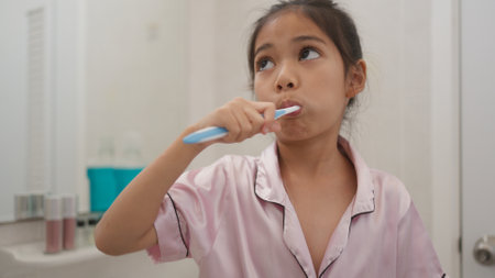 Morning routine, smiling happy Asian girls brushing teeth with a toothbrush. Dental hygiene of little girls, medical care.の写真素材