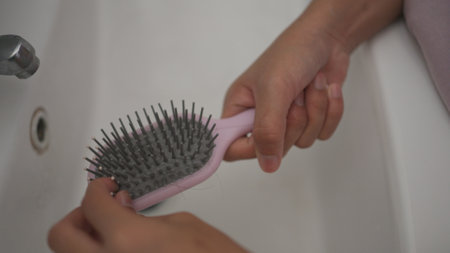 woman show her brush for presentation hair loss problem and looking at her hairの写真素材
