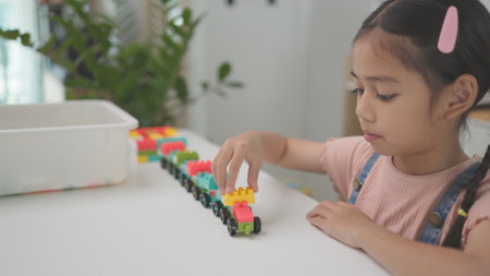 Child playing with colorful toy blocks. Kids play. Little girls building a tower of block toys. Educational game for babies and toddlers. Children build a toy houseの写真素材