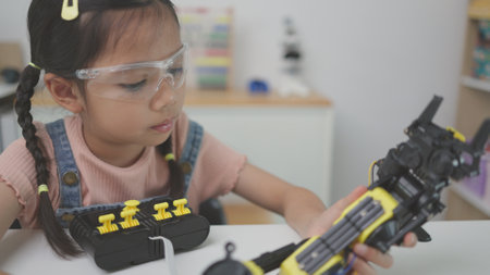 Robotics programming class. Children construct and code Robots. STEM education using constructor blocks and laptop, remote control joystick. Technology educational development for school kidsの写真素材