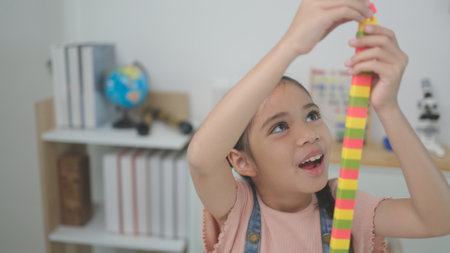 Child playing with colorful toy blocks. Kids play. Little girls building a tower of block toys. Educational game for babies and toddlers. Children build a toy houseの写真素材