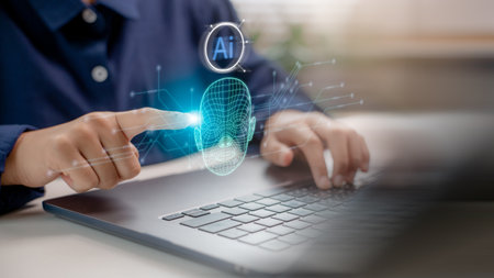 User interacting with facial recognition AI system on laptop, representing biometric authentication, deepfake technology, digital identity verification, and artificial intelligence interface.の写真素材