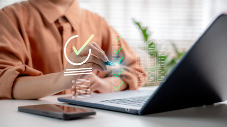 A businessman approving digital documents on a laptop with a virtual checklist interface. Concept of online approval, document management system, and paperless workflow.の写真素材